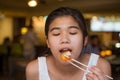 Teen girl eating jumbo shrimp with chopsticks at restaurant Royalty Free Stock Photo