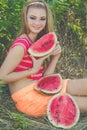 Teen girl is eating watermelon in green park