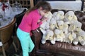 Teen girl and eleven soft toy white sheep on brown