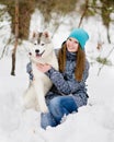 Teen girl embracing hasky dog in winter park