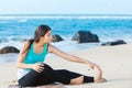 Teen girl exercising on sandy beach of Hawaii near ocean