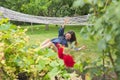 Teen girl falling from hammock, spring garden background