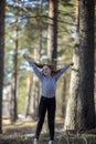 Teen girl with fiery red hair having fun in the pine park. Royalty Free Stock Photo