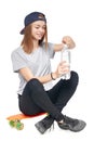 Teen girl in full length sitting on skate board Royalty Free Stock Photo