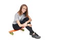 Teen girl in full length sitting on skate board Royalty Free Stock Photo