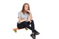 Teen girl in full length sitting on skate board Royalty Free Stock Photo