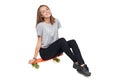 Teen girl in full length sitting on skate board Royalty Free Stock Photo