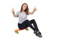 Teen girl in full length sitting on skate board Royalty Free Stock Photo