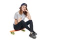 Teen girl in full length sitting on skate board Royalty Free Stock Photo