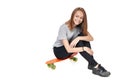 Teen girl in full length sitting on skate board Royalty Free Stock Photo