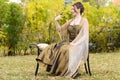 Teen girl in garden with goldfinch bird on finger