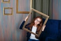 Teen girl with glasses holding an empty picture frame. Royalty Free Stock Photo