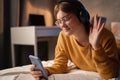 Teen girl having video chat with friends using phone camera while lying on bed in student dormitory at night. Royalty Free Stock Photo