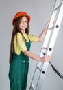 teen girl in helmet and boilersuit on stepladder. child on ladder wear hard hat. kid builder on construction site