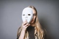 Teen girl hiding face behind mask Royalty Free Stock Photo