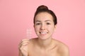 Teen girl holding acne healing patches on pink background