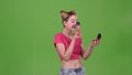 Teen girl holding a brush in her hand and powdering her face. Green screen