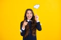 Teen girl holding clouds empty space, thinking bubble, comment cloud over yellow background. Royalty Free Stock Photo