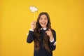 Teen girl holding clouds empty space, thinking bubble, comment cloud over yellow background. Royalty Free Stock Photo