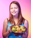 Teen girl holding a colander full of apples
