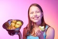 Teen girl holding a colander full of apples