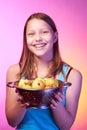 Teen girl holding a colander full of apples