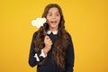 Teen girl holding thinking bubble, comment cloud over yellow background. Excited face. Amazed expression, cheerful and Royalty Free Stock Photo