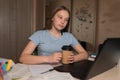 Teen girl, home lessons laptop, cup of coffee tea, watching videos, learning lessons, home education, preparing for exam Royalty Free Stock Photo