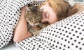 Teen girl hug cat in bed, Royalty Free Stock Photo