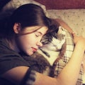Teen girl hug cuddle cat in bed