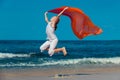 Teen girl jumping on the beach at blue sea shore in summer vaca Royalty Free Stock Photo