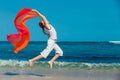 Teen girl jumping on the beach at blue sea shore in summer vaca Royalty Free Stock Photo