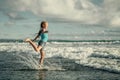 Teen girl jumping on the beach at blue sea shore Royalty Free Stock Photo