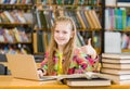 Teen girl with laptop in library showing thumbs up Royalty Free Stock Photo