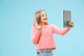 Teen girl with laptop. Love to computer concept. Attractive female half-length front portrait, trendy blue studio