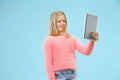 Teen girl with laptop. Love to computer concept. Attractive female half-length front portrait, trendy blue studio Royalty Free Stock Photo