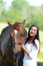 A teen girl laughs with her horse while out in a field. Royalty Free Stock Photo