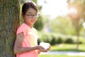 Teen girl leaning against tree in park Royalty Free Stock Photo