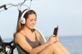 Teen girl listening music from a smart phone on the beach Royalty Free Stock Photo
