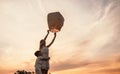 Teen girl with little brother releasing sky lantern