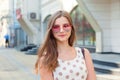 Teen girl with long brunette pink hat heart shaped sunglasses looking away smiling Royalty Free Stock Photo