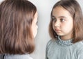 Teen girl looks at her reflection in the mirror. Royalty Free Stock Photo