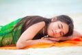 Teen girl lying down on Hawaiian beach, resting by ocean Royalty Free Stock Photo