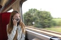 Teen girl in mask talking on smartphone in train