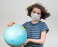 Teen girl in a medical mask holds the globe