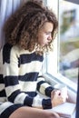 Teen girl with mug by window Royalty Free Stock Photo