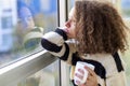 Teen girl with mug by window Royalty Free Stock Photo