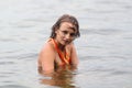 Teen girl in orange dress dabbles in water Royalty Free Stock Photo