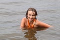 Teen girl in orange dress dabbles in water