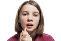 Teen girl paints lips with lipstick. Close-up. Isolated on a white background Royalty Free Stock Photo